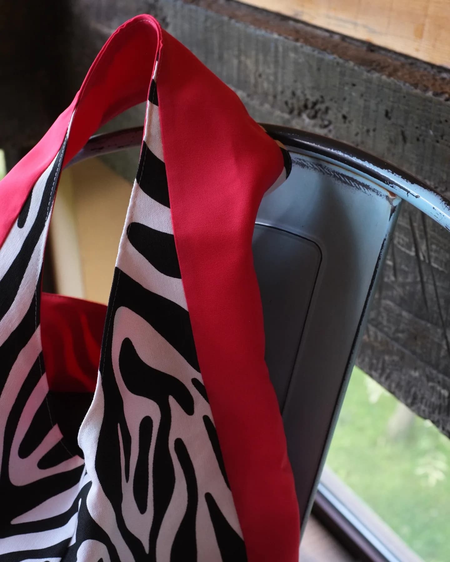 Zebra Crvena obješena o naslon drvene stolice na terasi